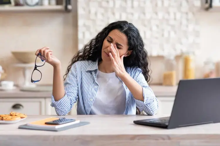 o femeie in stare de oboseală cu laptopul lângă ea o femeie in stare de oboseală cu laptopul lângă ea
