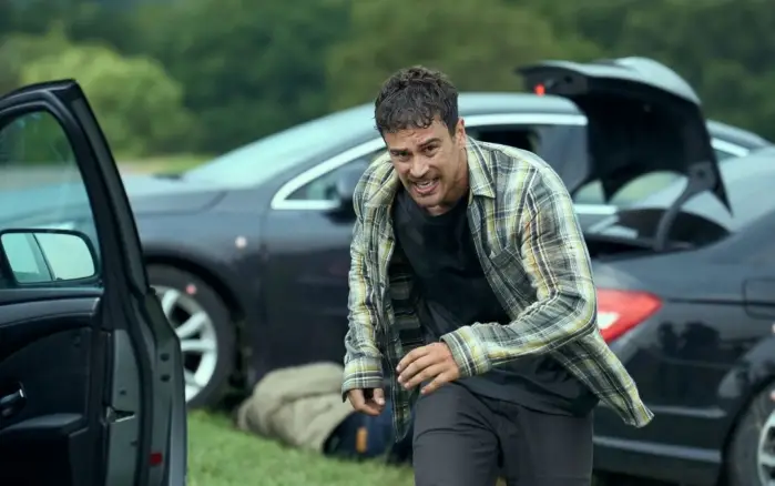Theo James în scenă tensionată din Fuze (2025) Theo James surprins într-un moment de maximă tensiune lângă mașini, din thrillerul britanic Fuze (2025) regizat de David Mackenzie